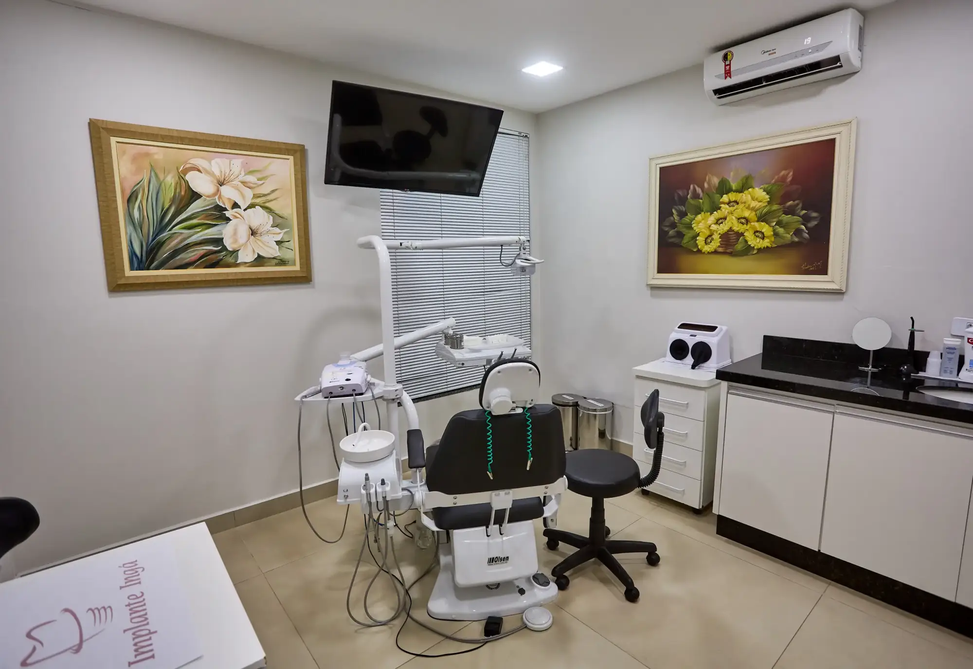 Consultório bem iluminado e organizado com equipamentos odontológicos visíveis.
